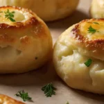 Golden-brown potato knish on baking sheet, traditional Jewish pastry